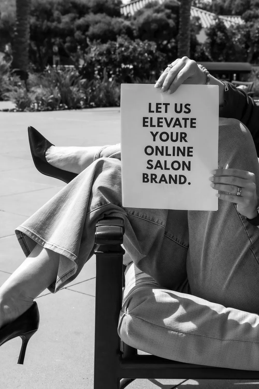 Rebekah Harrison of Storm Salon Social holding a hand-lettered sign