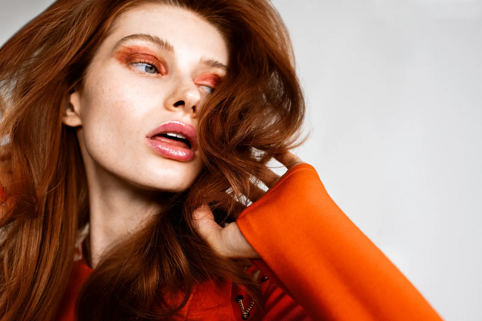 A model in orange with copper hair, from a Frankie by Rizzieri shoot