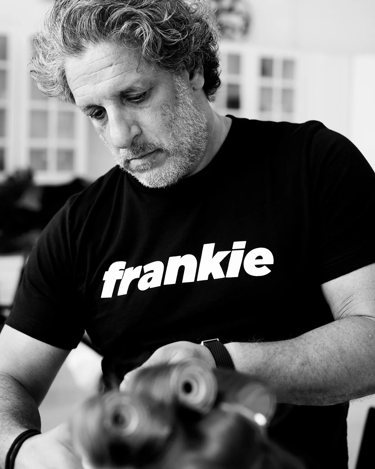 A stylist at Frankie by Rizzieri working on a client, in black and white